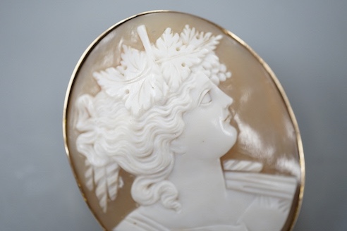 A yellow metal mounted oval cameo shell brooch, carved with the bust of a lady to sinister, 47mm, gross weight 16.7 grams.